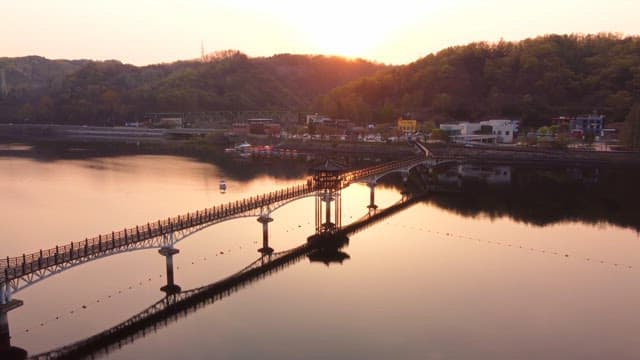 Scenic bridge over a calm river at sunset