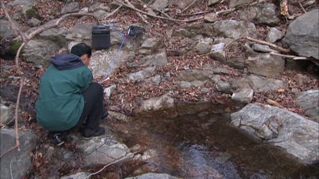 Man recording the sound of a stream in the forest