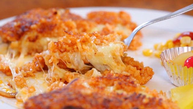 Spoonful of cheese-topped crispy rice