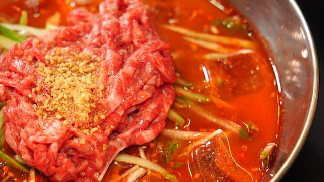 Cold Yukhoe soup with fresh vegetables and ice