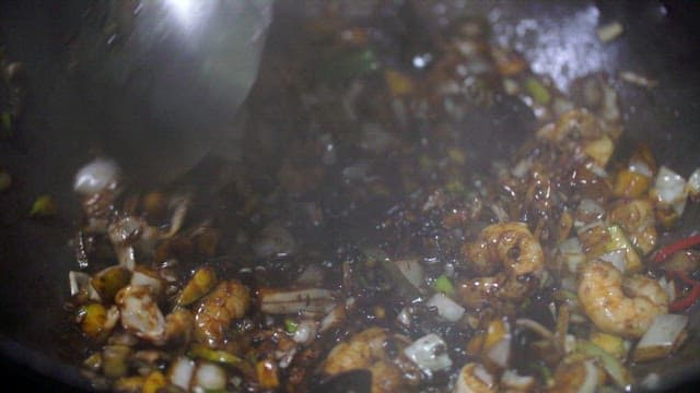 Stir-frying vegetables with black bean sauce in a hot wok