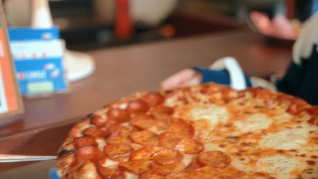 Freshly baked pepperoni pizza being served
