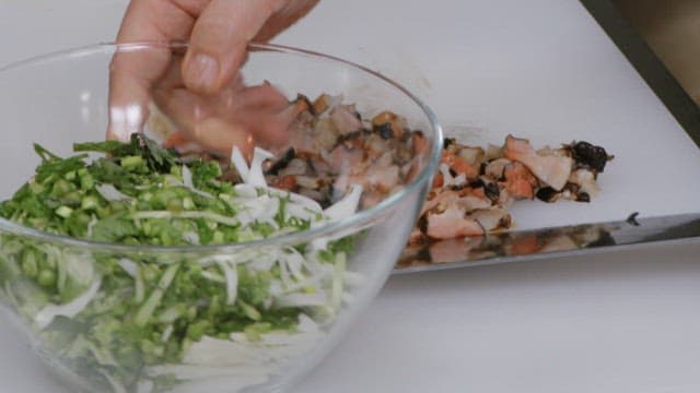 Mixing finely chopped conch and vegetables