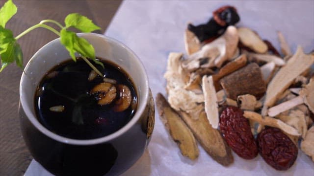 Herbal tea with a cup and medicinal herbs on a wooden table