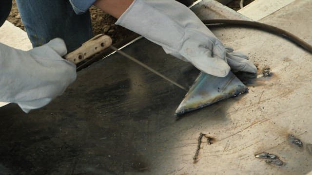 Worker welding metal with sparks flying