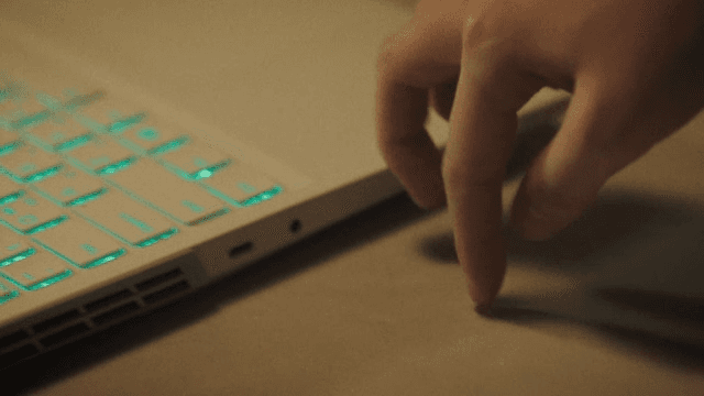 Fingers playfully pressing the laptop keyboard on the table