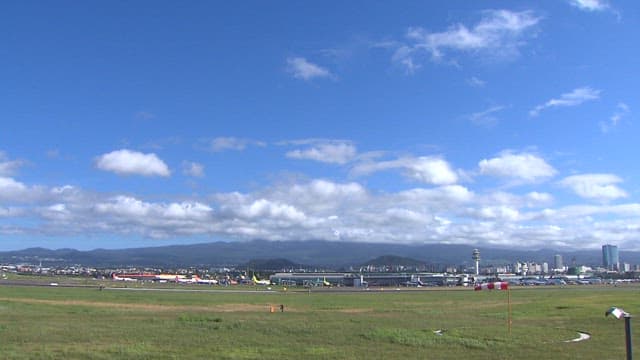 Expansive View of Airport with Cityscape and Mountains