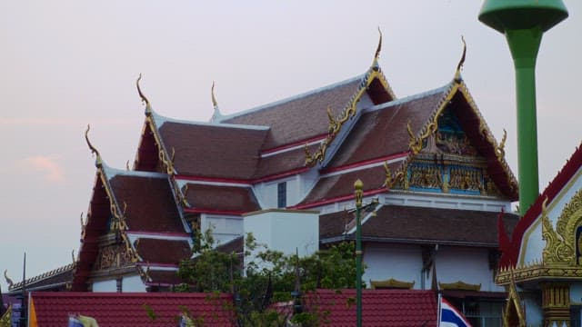 Ornate Thai temple roof during a tranquil evening.