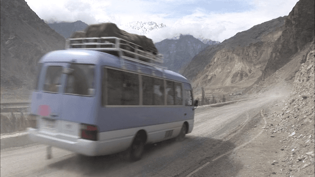 Dusty Mountain Road with Passing Bus