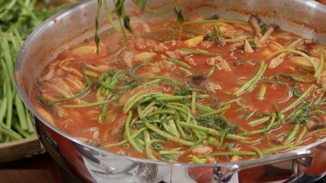 Transferring water parsley from hot pot to a plate