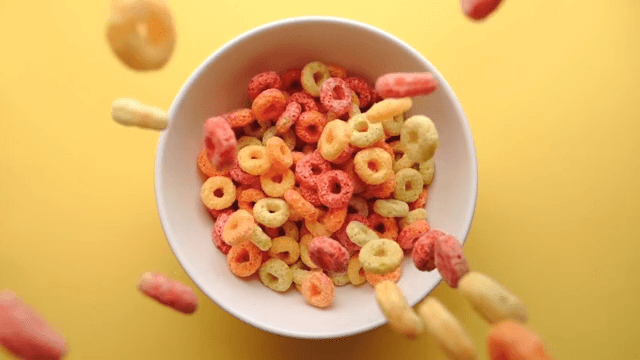 Slow motion of colorful cereal falling into a bowl