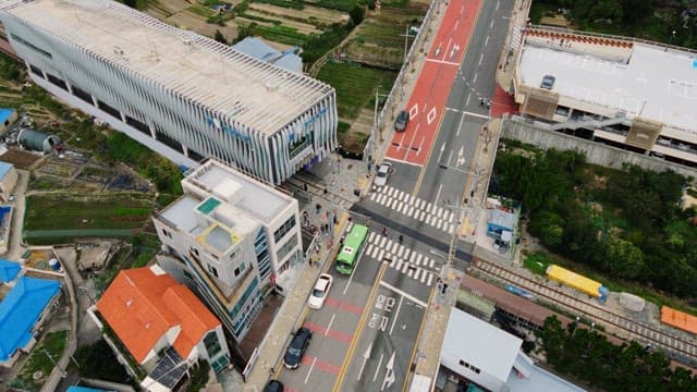 Road with pedestrians and vehicles near a train station