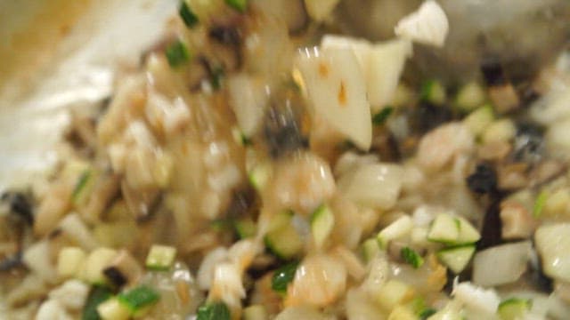 Stir-fried freshwater snail and chopped vegetables in a hot pan