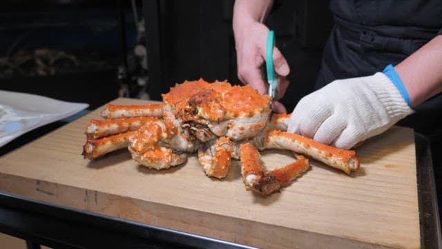Well-cooked king crab being prepared on a cutting board