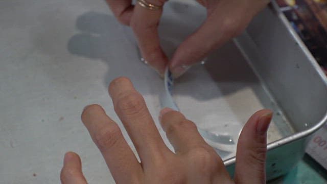 Soaking text labels in water glue in an aluminum tray