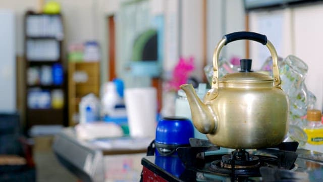 Metal kettle on top of a gas stove
