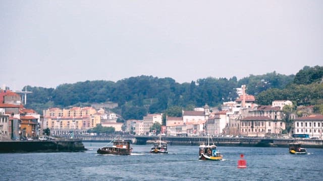 Colorful boats cruising by a historic riverside