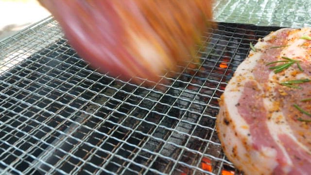 Juicy seasoned steaks grilling over charcoal flames