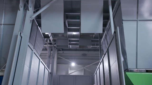 Plastic recycling facility with a large pile of mixed plastics on the conveyor belt