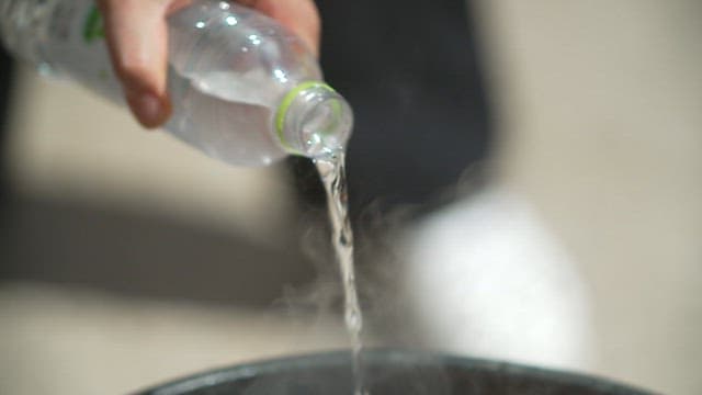Sauce and meat being stir-fried over high heat in a large wok