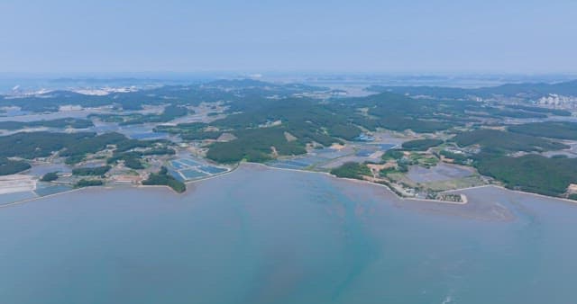 Scenery of a Coastal Village with a View of Farms