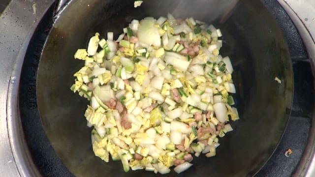 Stir-frying meat and vegetables in a wok with black bean paste