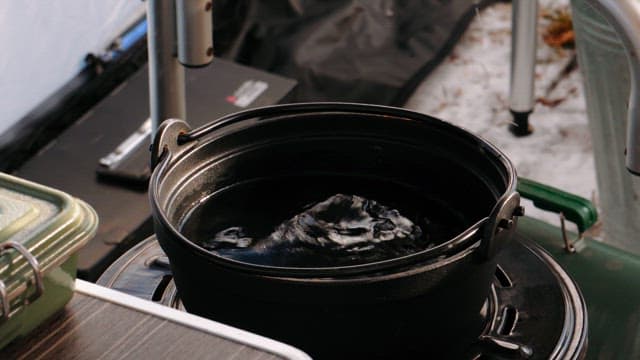 Warming Sake in a Black Pot Filled with Hot Water