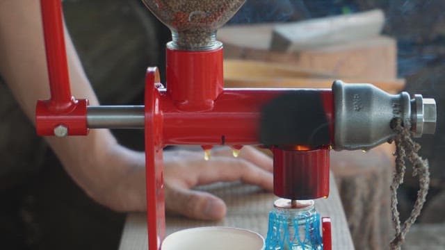 Hand pressing oil from seeds using a machine