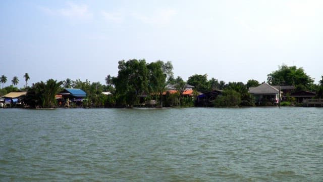 Riverside village with boats passing by on a sunny day