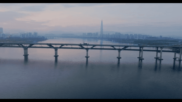 Bridge over a river with city skyline at sunset
