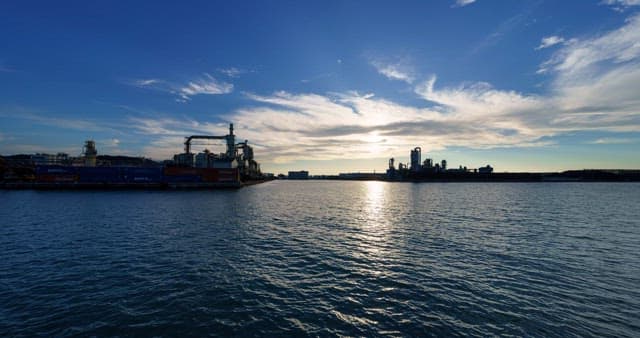 Industrial complex landscape near the sea from day to evening