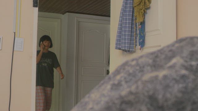 Woman talking on the phone and entering a cozy room