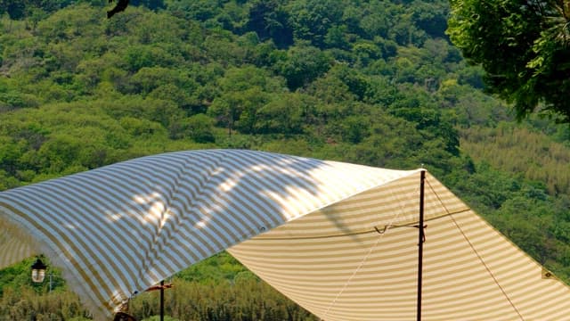 Sunny striped canopy and green mountains