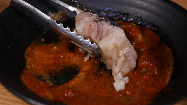 Scene of putting sauce on boiled pork slice