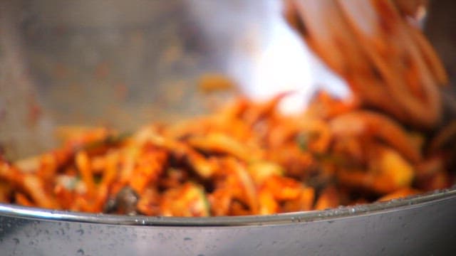 Mixing oyster mushrooms and vegetables with spicy seasoning