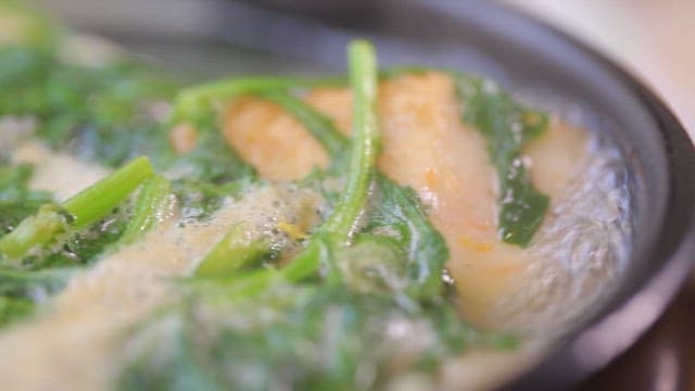 Warm udon noodles soup with fish cake and vegetables