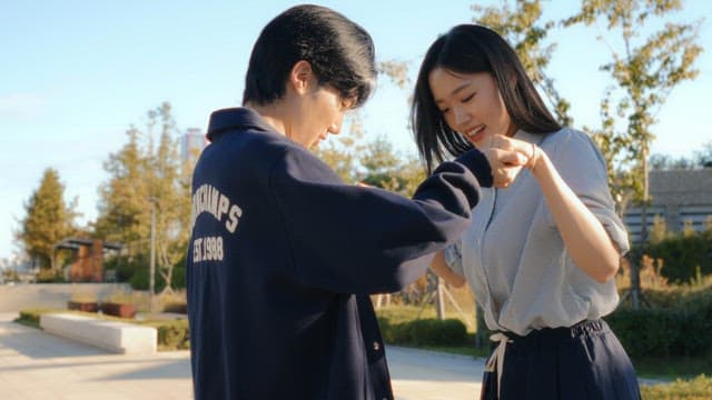 Man who helps a woman skateboard