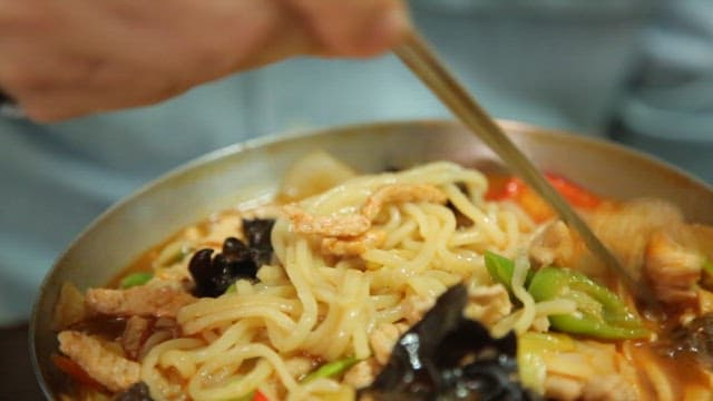 Stirring spicy jjambbong with chopsticks with lots of meat
