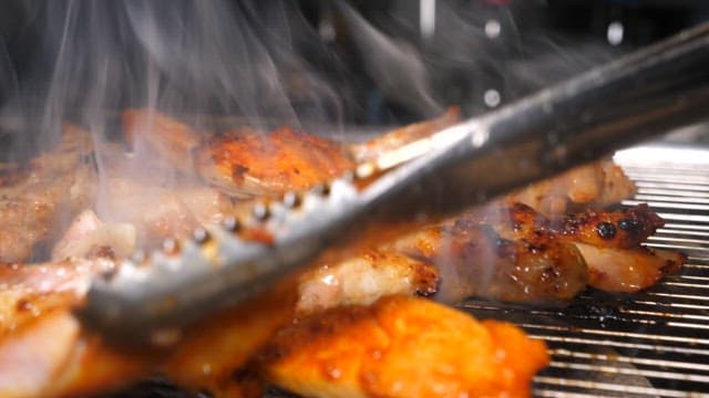 Grilled Chicken Sizzling on a Grill of Barbecue