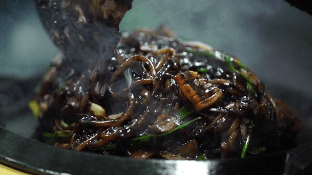 Seafood Jjajang noodles being cooked on a hot plate