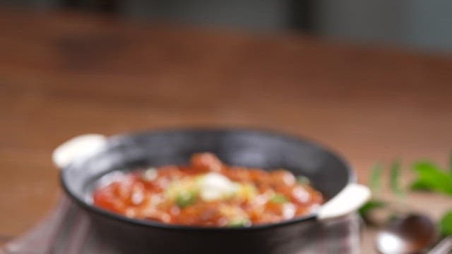 Bowl of spicy soup neatly arranged on a wooden table