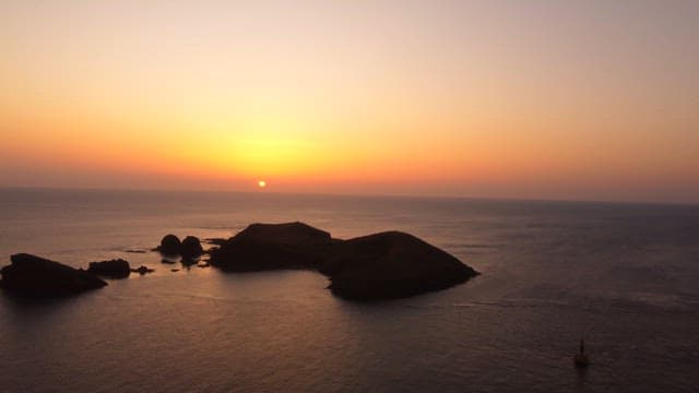 Sunset over a tranquil ocean with islands