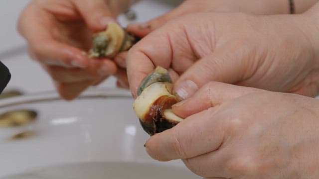 People preparing shellfish in a kitchen