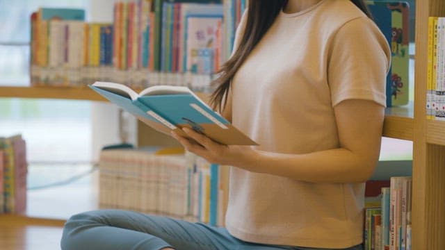 Woman Reading a Book in Library
