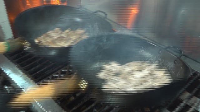 Meat cooked over intense flames in a restaurant kitchen