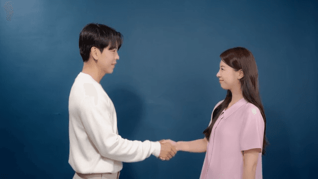 Man and woman greeting and shaking hands indoors