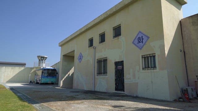 Prison Building Wall and Convoy Bus in Front of it