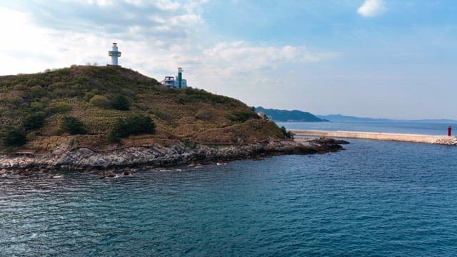 Lighthouse on a coastal hill with a view of the sea