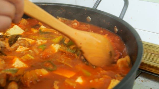 Spicy and hearty kimchi stew boiling in a pot