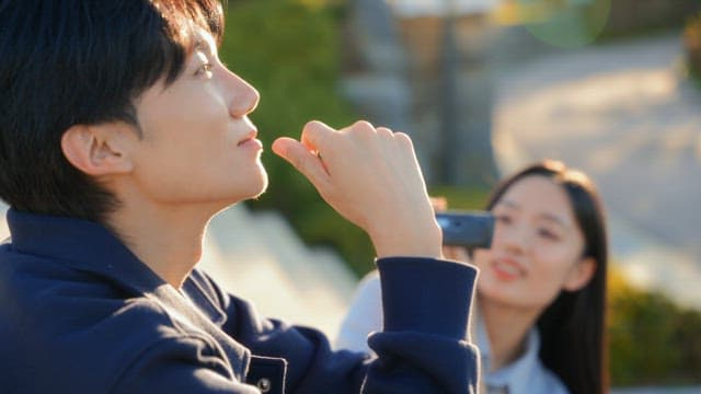 Couple filming a video with a camcorder in the park